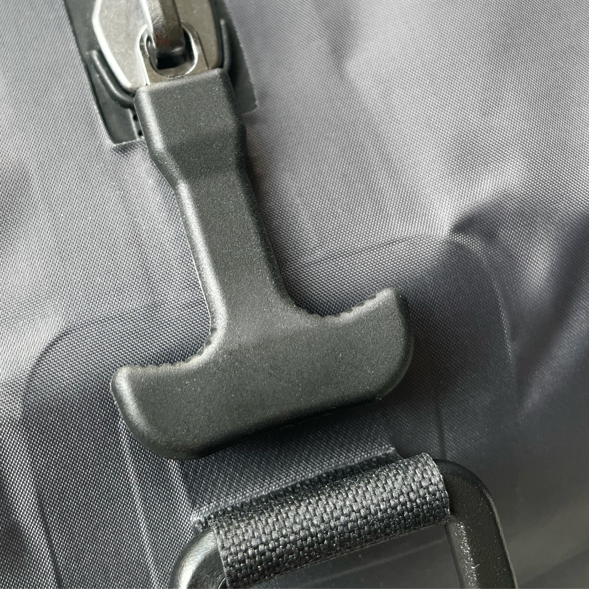 Close-up of zip handle and buckle showing compression bag texture